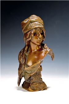 A bronze bust of a draped figure with a turban, featuring intricate surface textures and warm metallic tones.