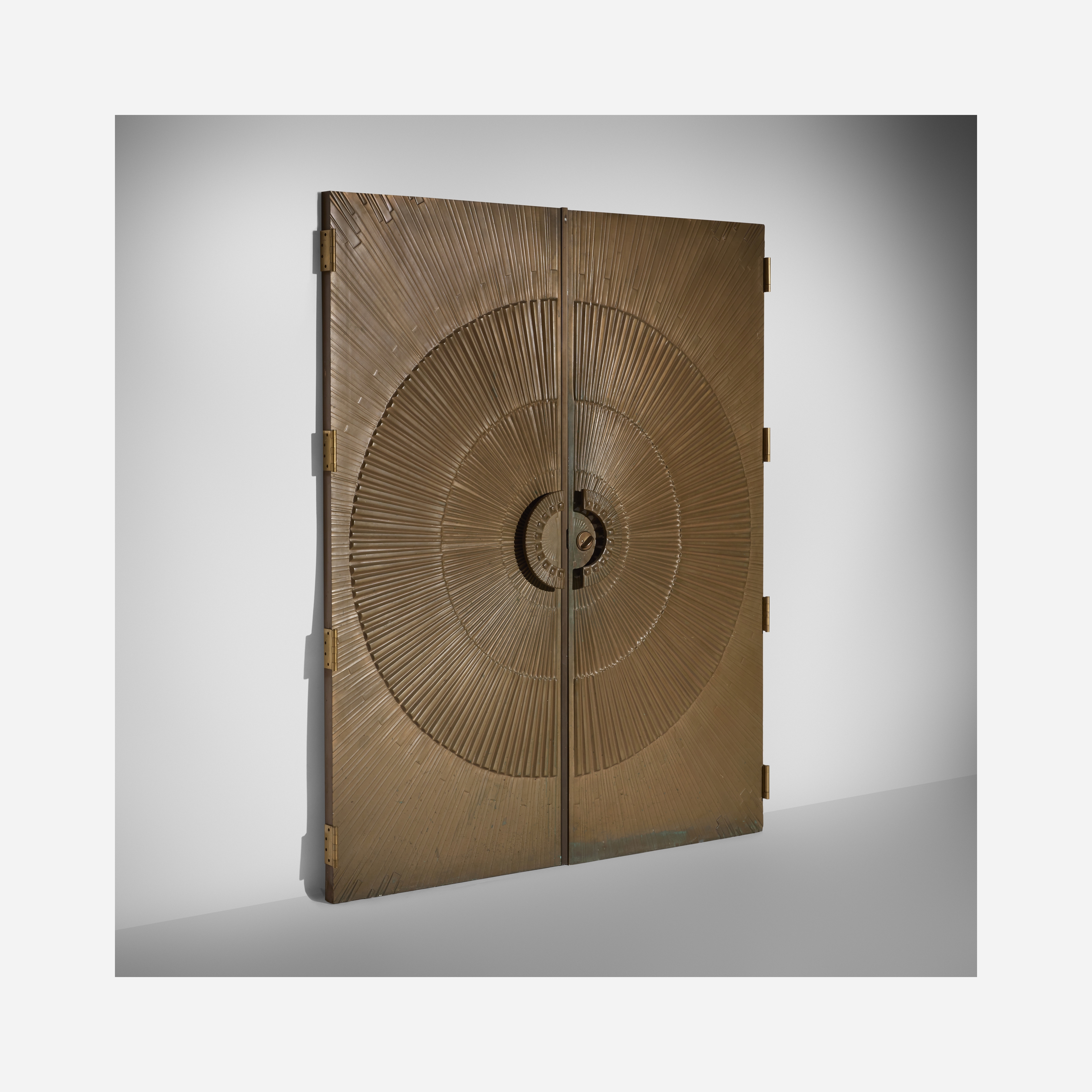 A golden cabinet with a sunburst design on its doors.