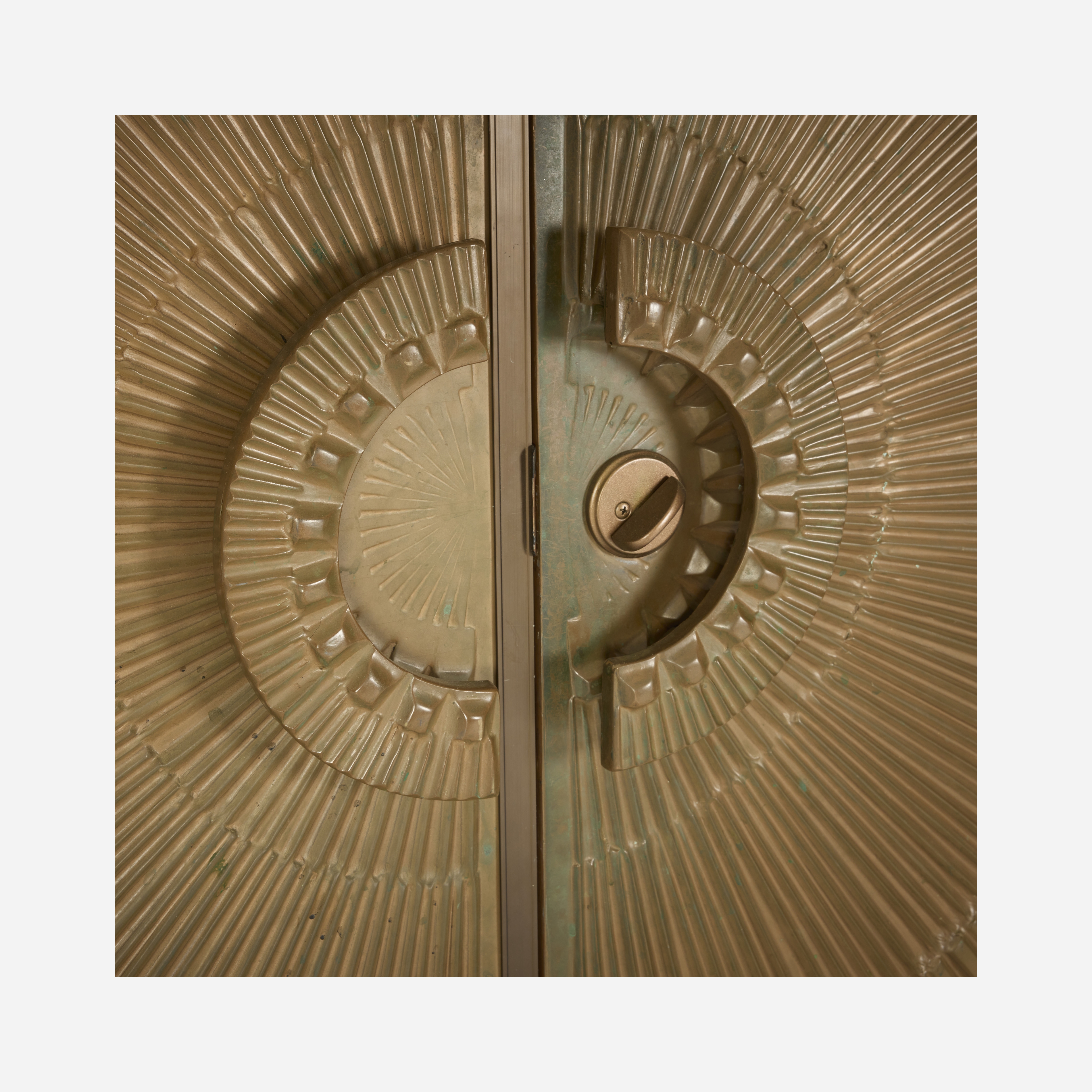 A golden cabinet with a sunburst design on its doors.