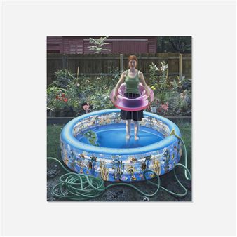 A person stands in an inflatable pool holding a pink ring, surrounded by garden greenery and a coiled hose.