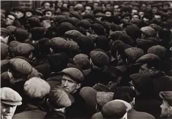 A dense crowd of men in caps, captured in a black-and-white photograph.