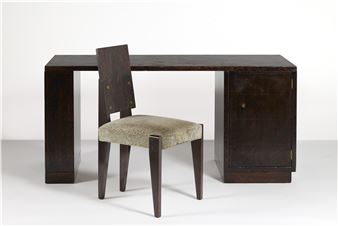 A minimalist interior scene featuring a dark wooden desk and a matching upholstered chair against a stark white background.