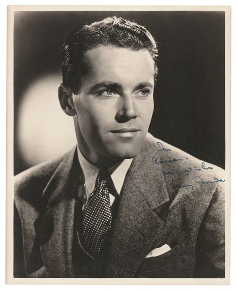 A black-and-white portrait of a man in a suit with handwritten text on his shoulder.