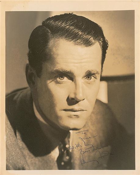 A monochrome portrait of a man with intense eyes and neatly styled hair, captured in dramatic lighting.