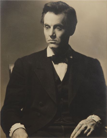 A formal portrait of a man in a suit with a bow tie, captured in sepia tones.