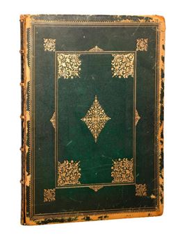 An antique book with a dark green cover and ornate gold floral patterns.
