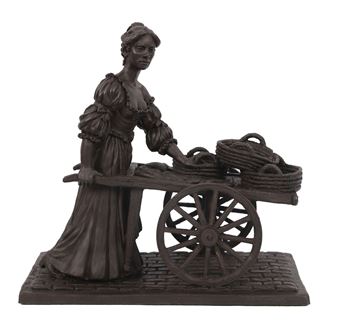 A bronze statue of a figure pushing a cart with woven baskets.