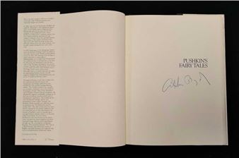 An open book with text on the left and a title with a signature on the right.