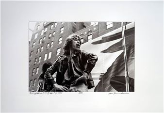 A black-and-white photograph capturing a candid moment of a person in motion against an urban backdrop.