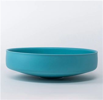 A minimalist ceramic bowl in a vibrant turquoise hue.