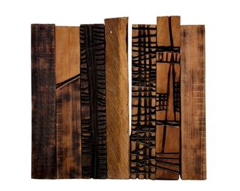 A rustic wood relief panel featuring carved geometric patterns and natural grain textures.