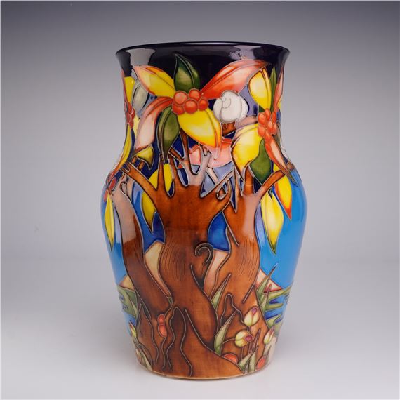 A colorful ceramic vase featuring a stylized tree design with vibrant leaves and berries.