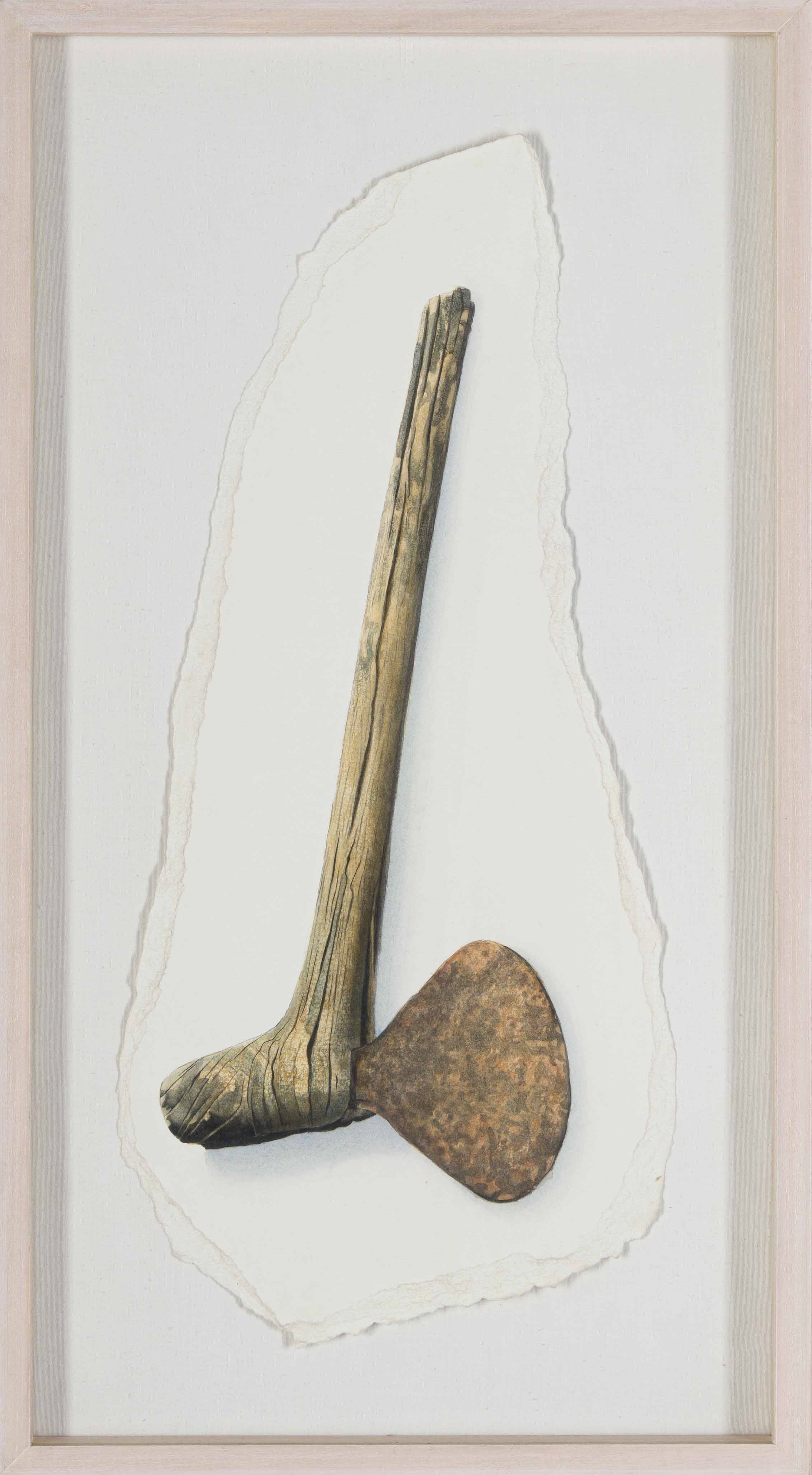 A rustic wooden axe head mounted on a textured white background.
