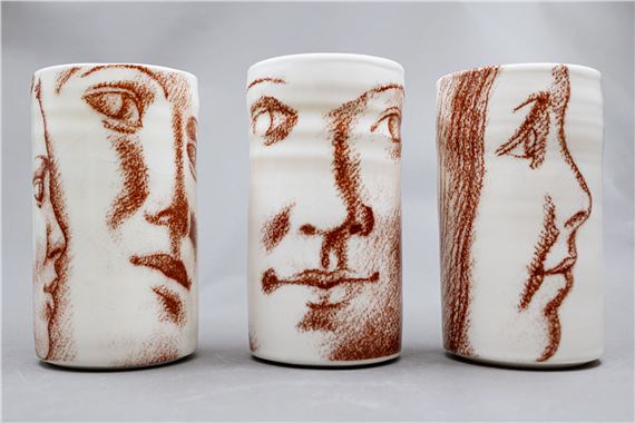 Three cylindrical ceramic vessels feature abstract, sketch-like portraits in earthy tones.