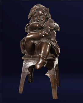 A bronze sculpture of a seated figure holding a shoe.