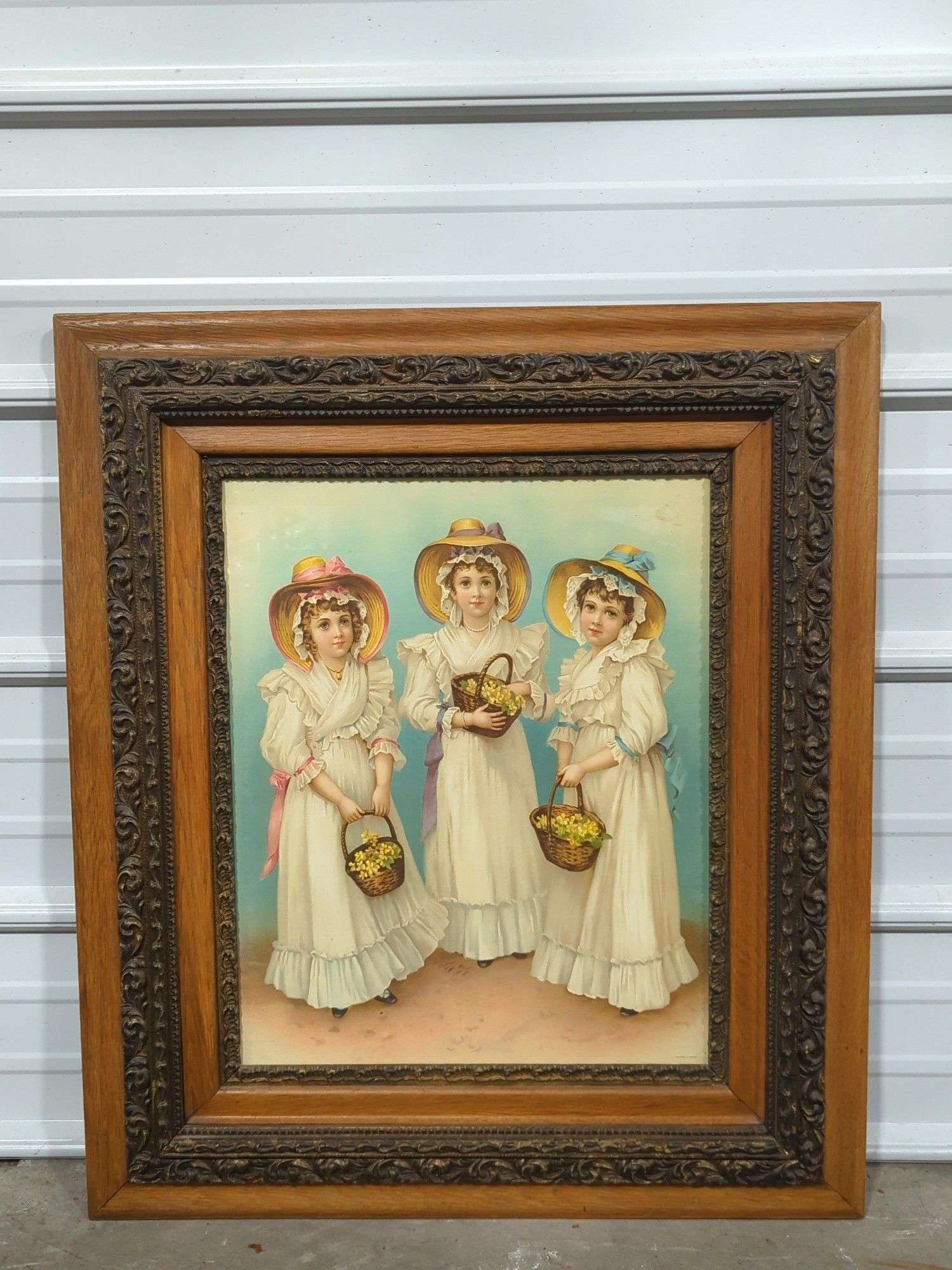 Two framed paintings depicting women in historical dress, one with three figures and another with two figures under a floral arch.