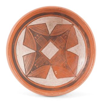 A terracotta bowl featuring a symmetrical geometric pattern with diamond and star motifs.