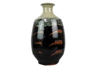 A glossy ceramic vase with a dark, mountain-like glaze pattern.