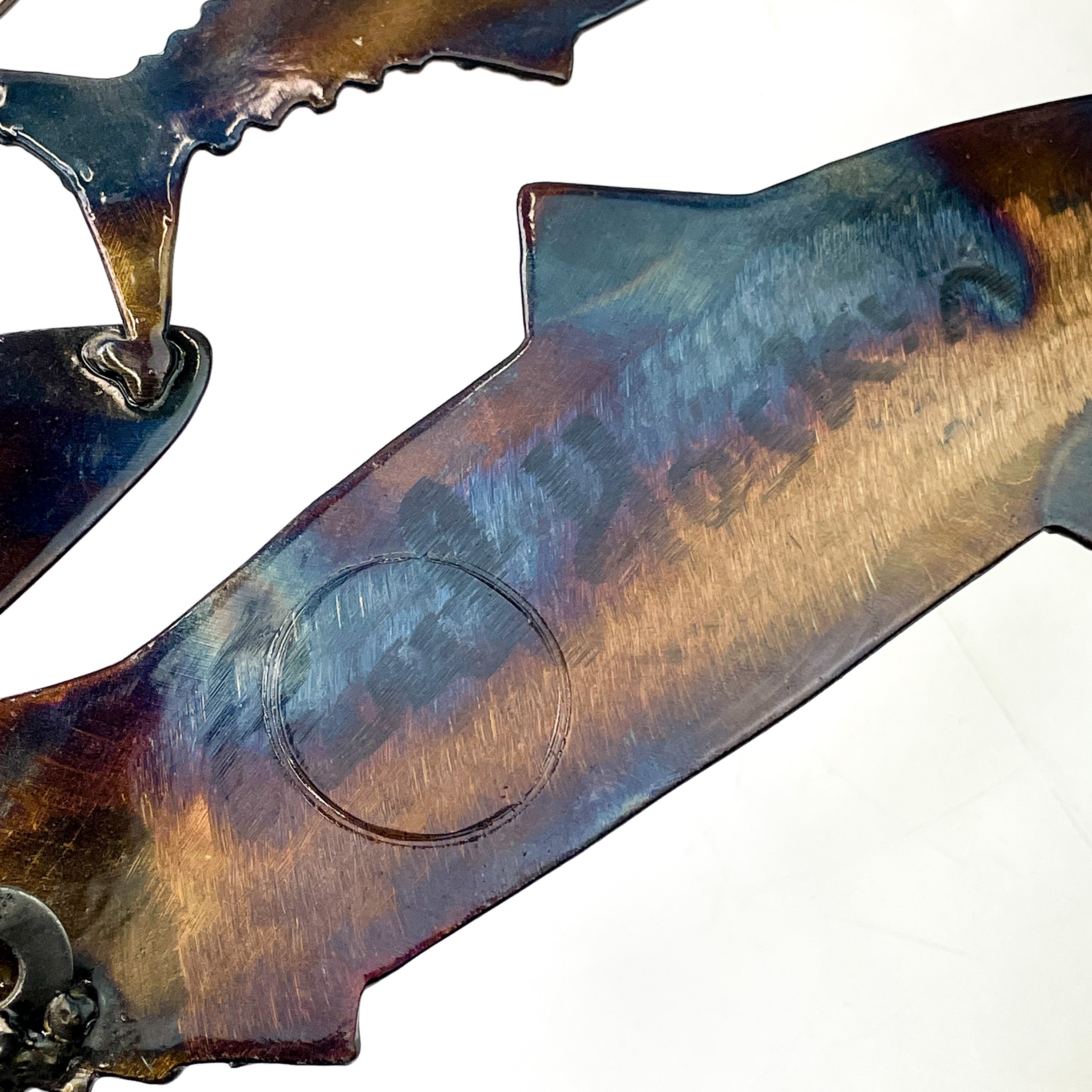A metal wall art piece featuring a school of fish in shades of blue and brown.