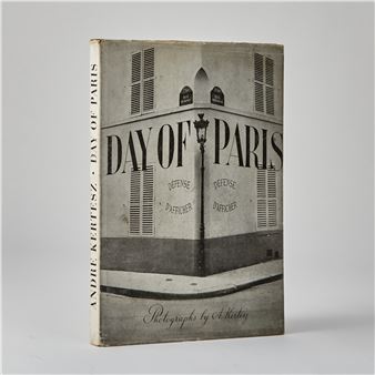 A monochromatic book cover featuring a corner building with louvered shutters and bold typography.