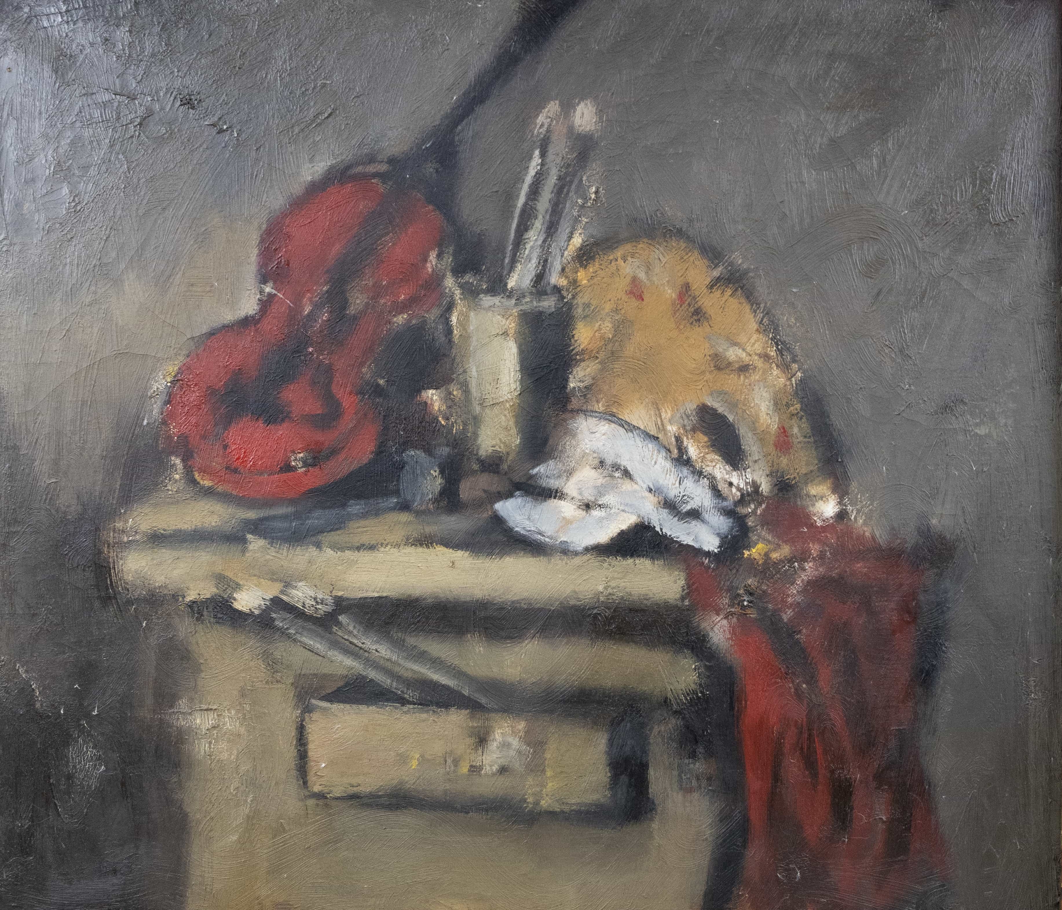 A painterly still life of an artist's desk with a red cloth, palette, and brushes.