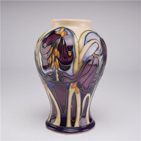 A ceramic vase featuring stylized floral patterns in deep purple, cream, and blue.