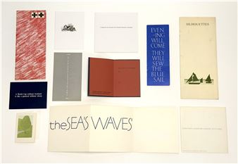 A flat-lay composition of various printed booklets and pamphlets arranged on a white surface.