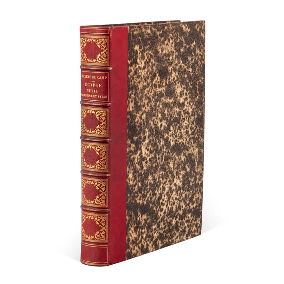 "A vintage book with a red cloth spine and a speckled brown cover."