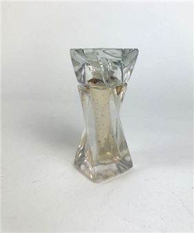 A clear glass candle holder with a twisted, geometric design and a visible wick.