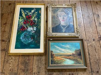 A collection of three framed paintings displayed on a rustic wooden surface.