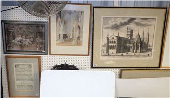 A collection of framed architectural and historical prints displayed on a pegboard wall.