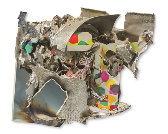 A chaotic assemblage of metallic and paper fragments forming a textured, abstract sculpture.