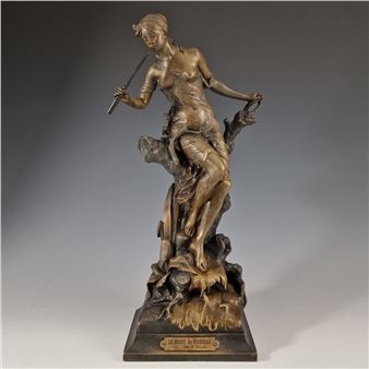 "A bronze sculpture of a reclining figure playing a flute, perched on a rocky base."