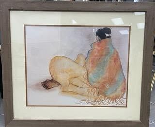 A framed watercolor painting of a figure in profile, seated and wrapped in a colorful shawl.