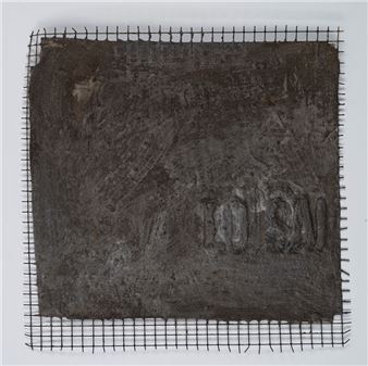 A textured, dark square relief mounted on a wire mesh grid.