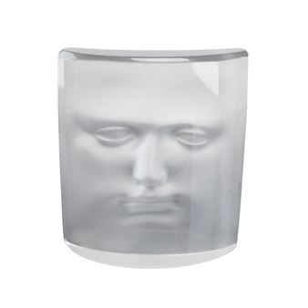 A translucent glass vessel featuring an embossed human face.