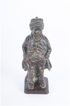A bronze sculpture of a seated figure in winter clothing.