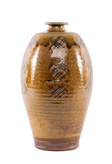 A tall, glazed ceramic vase with a geometric diamond pattern against a white background.