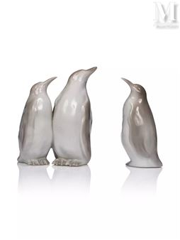 A trio of glossy white penguin figurines posed against a stark white background.
