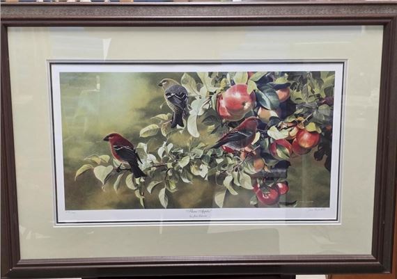 A framed botanical illustration featuring small birds perched on a branch laden with red apples and green leaves.