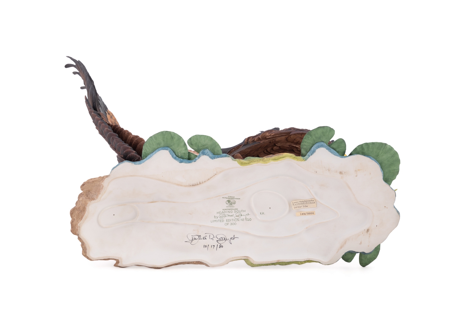 A sculptural diorama featuring two geese on a lily pad base.