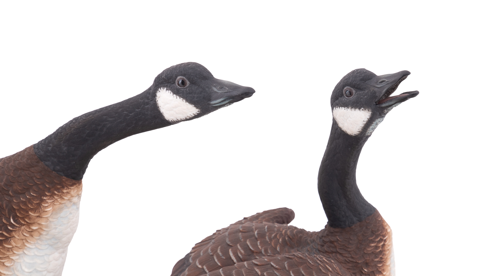 A sculptural diorama featuring two geese on a lily pad base.
