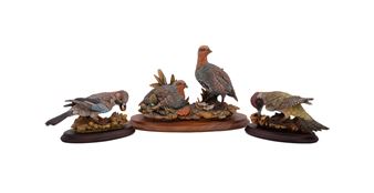 A set of four sculpted birds displayed on individual wooden bases.