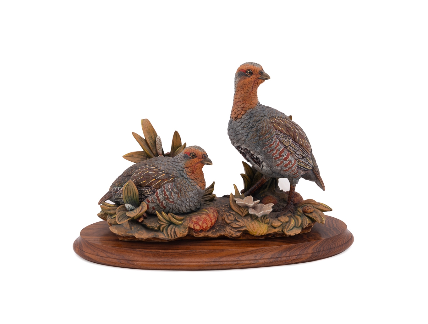A set of four sculpted birds displayed on individual wooden bases.