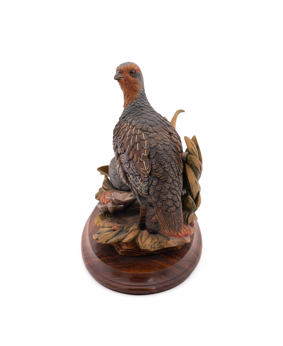 A set of four sculpted birds displayed on individual wooden bases.
