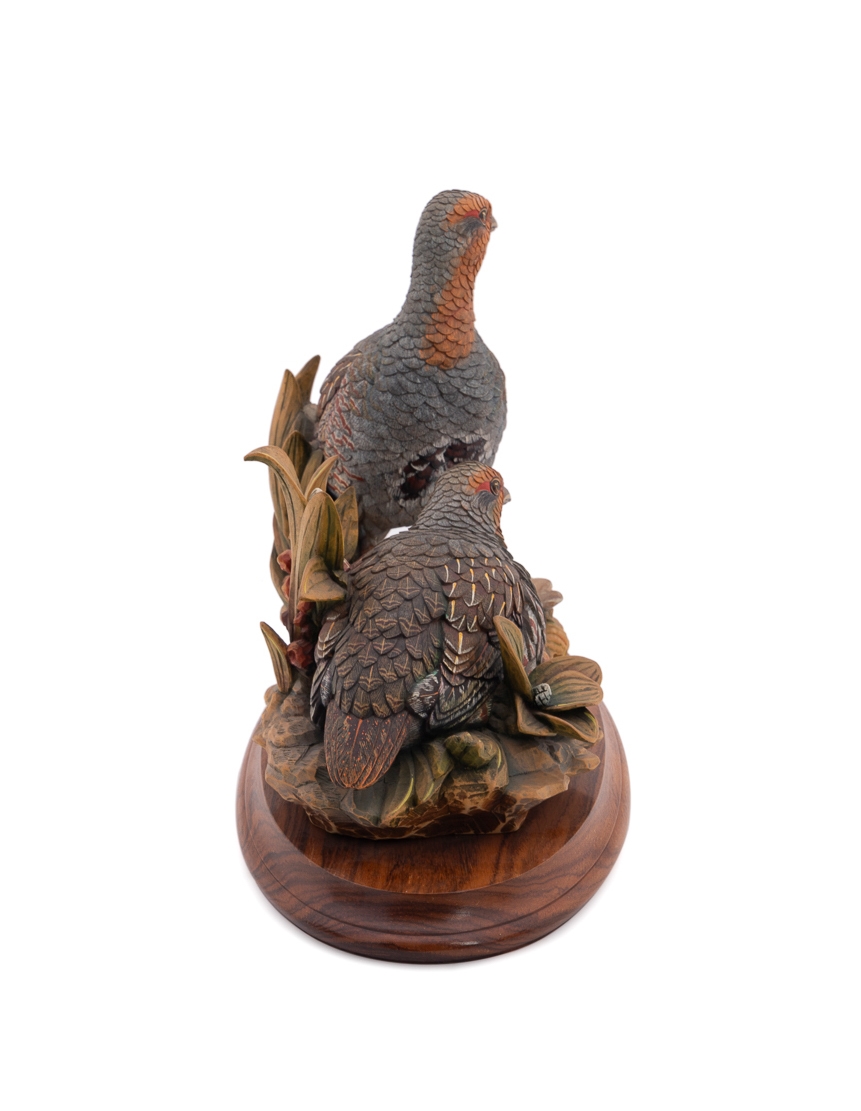 A set of four sculpted birds displayed on individual wooden bases.