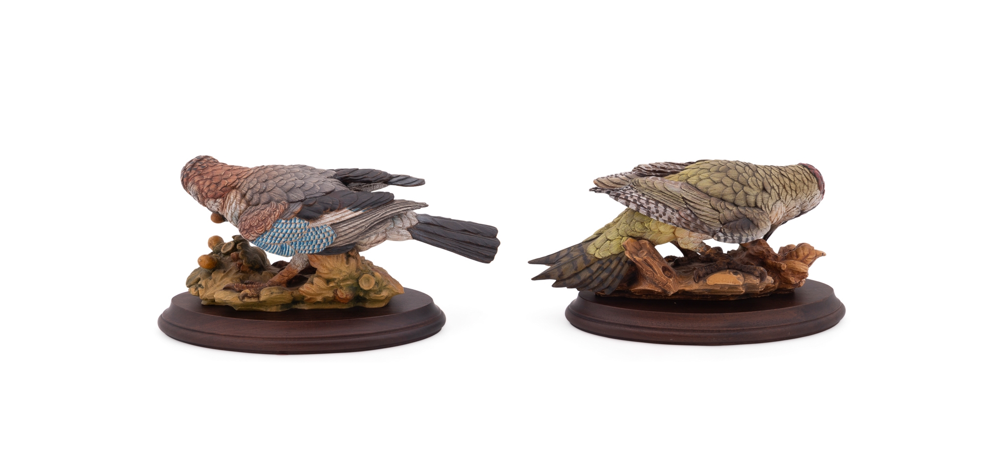 A set of four sculpted birds displayed on individual wooden bases.