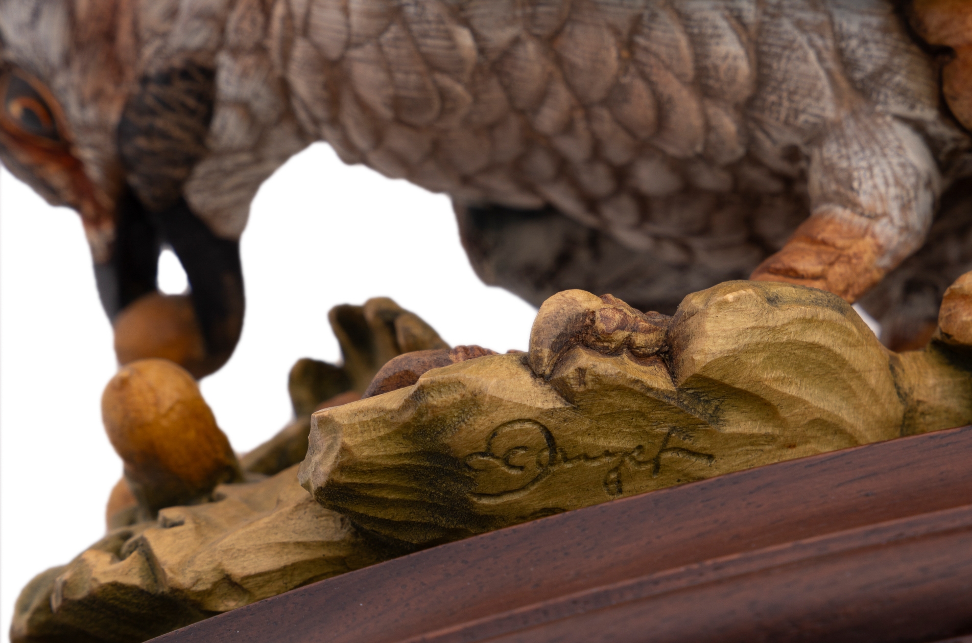 A set of four sculpted birds displayed on individual wooden bases.