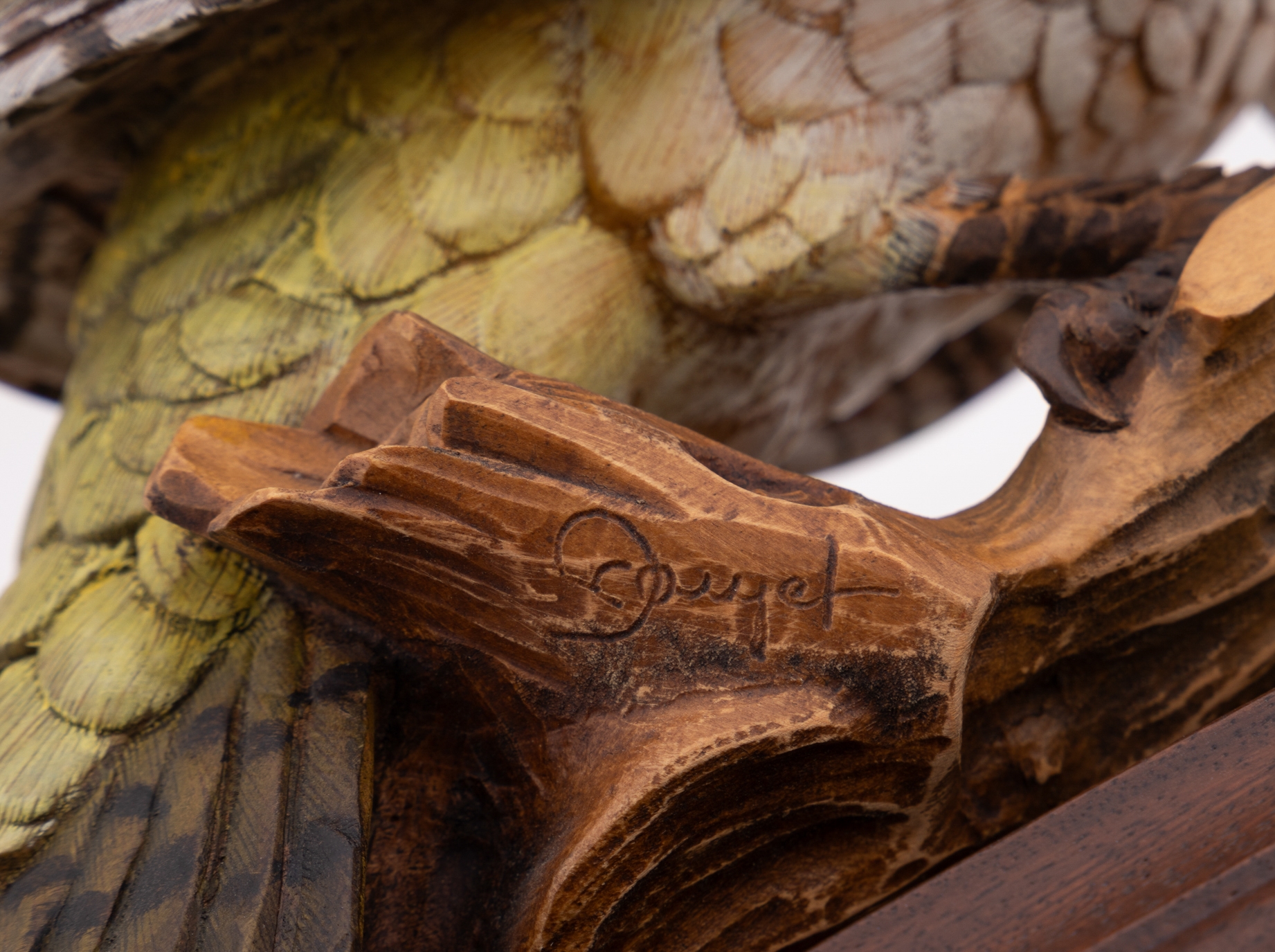 A set of four sculpted birds displayed on individual wooden bases.