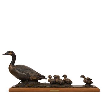 A bronze sculpture of a goose leading five ducklings on a wooden base.